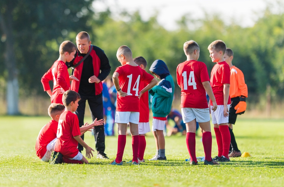 Coach discussing tactics with grassroots football team