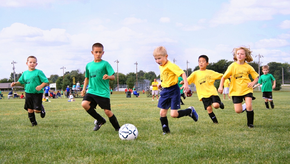 A group of children playing football in a local park