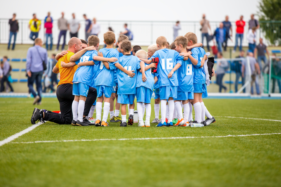 Grassroots football players in a huddle before the match