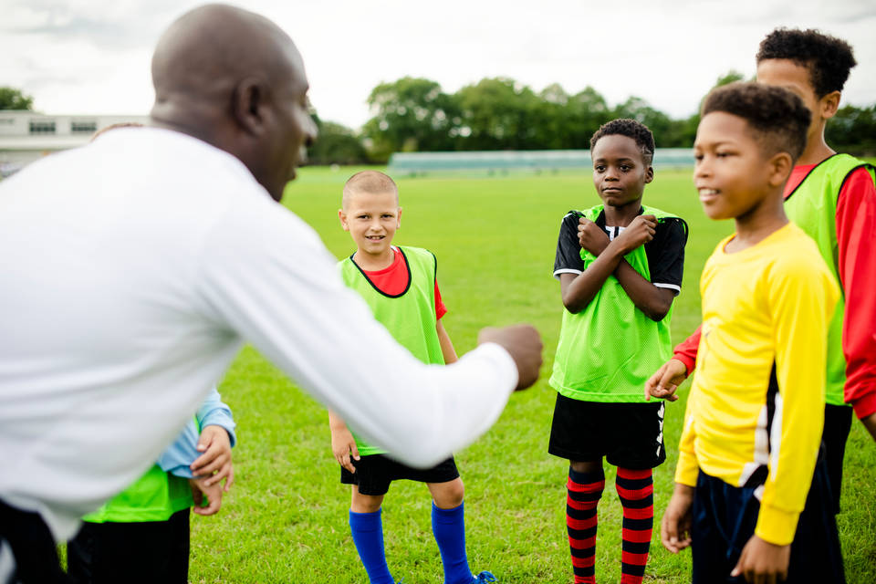 Coach with players at football training