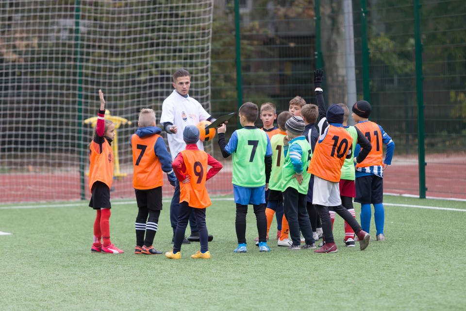 Coach with players at football training