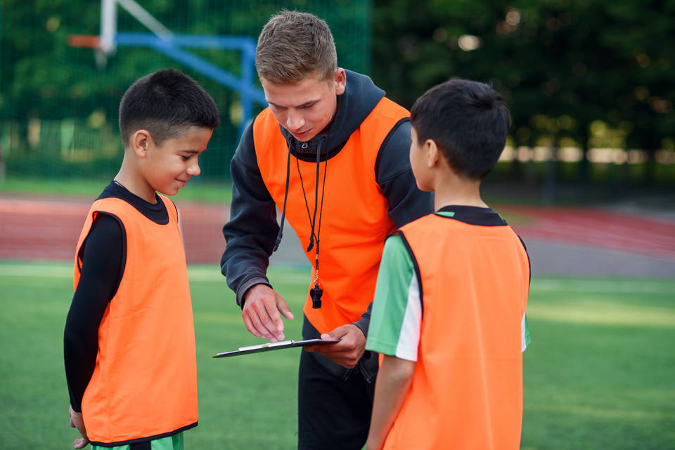 Coach with players at football training
