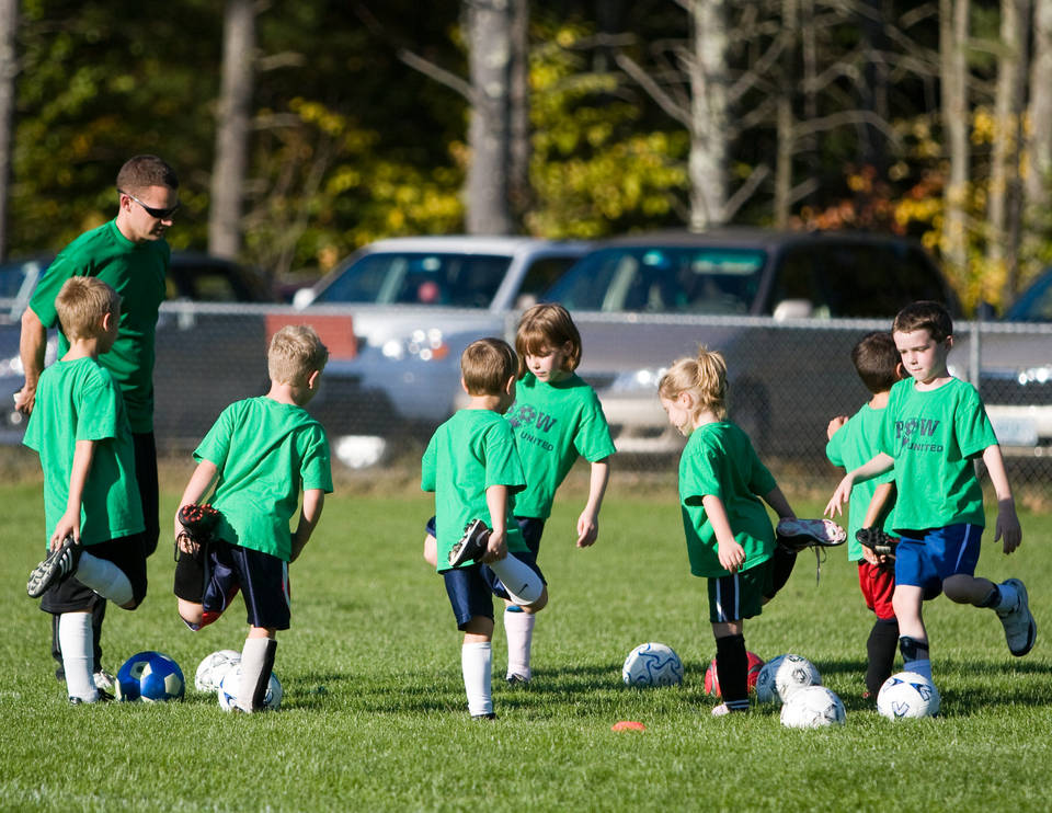 Coach with players at football training